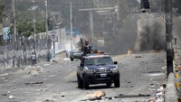 Polisi terlihat melakukan patroli untuk mengamankan kondisi yang mencekam di kota Port au Prince. Andres Martinez Casaf/Reuters.