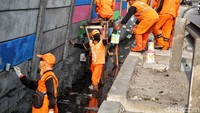 Sejumlah petugas PPSU mengecat tembok di sepanjang Jalan RE Martadinata, Jakarta Utara, Senin (9/7).