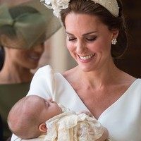 Kate yang menggendong sang pangeran tampil elegan berbalut suit dress keluaran rumah mode Alexander McQueen. Foto: Dok. Getty Images