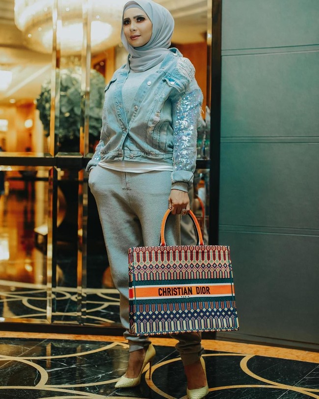 Gaya kasual Rozita selalu berkesan glamor. Seperti saat ia tampil membawa Dior Book Totebag dengan keindahan embroidery ini. Ia padukan tas bernuansa kasual dengan jaket jeans bertabur beading yang berkilau. Foto: Instagram/Rozitachewan1
