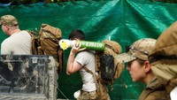 Para penyelam terlihat membawa tabung oksigen yang akan dipersiapkan untuk proses evakuasi 4 anak dan 1 orang pelatih yang masih terjebak di dalam gua. Tyrone Siu/Reuters.