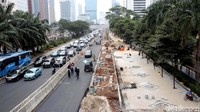 Para pekerja membangun trotoar di Jalan Sudirman, Jakarta Pusat, Selasa (10/7/2018).
