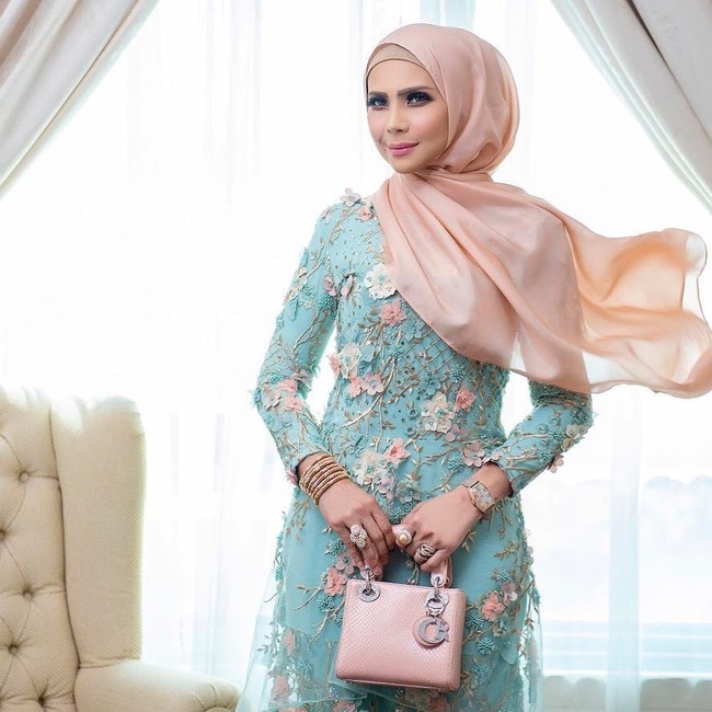 Rozita begitu lihai bermain warna. Tas dan busana yang ia pakai tak selalu sewarna, tapi selalu senada. Persis saat ia memakai dress berbahan lace ini. Ia padukan warna shawl yang ia pakai dengan Mini Lady Dior Bag berwarna rose. Foto: Instagram/Rozitachewan1