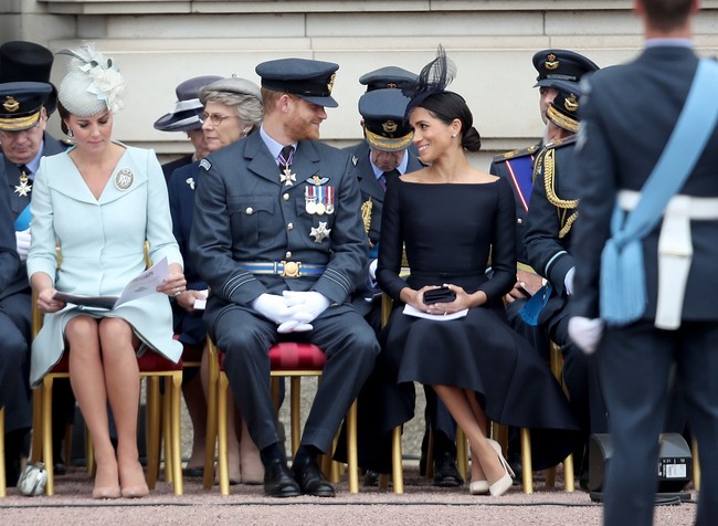 Meghan memadukan gaun hitam bersama topi dengan aksen lipit dari Stephen Jones.  Foto: Dok. Getty Images