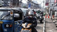 Seorang pemotor harus menunduk untuk menghindari kabel yang turun ke bawah tersebut.