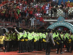 Saat akan keluar lapangan, para pemain Malaysia harus mendapat pengawalan polisi. ANTARA FOTO/Zabur Karuru.