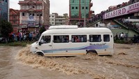 Ratusan keluarga harus mengungsi untuk sementara waktu karena area pemukiman mereka digenangi air. Navesh Chitrakar/Reuters.