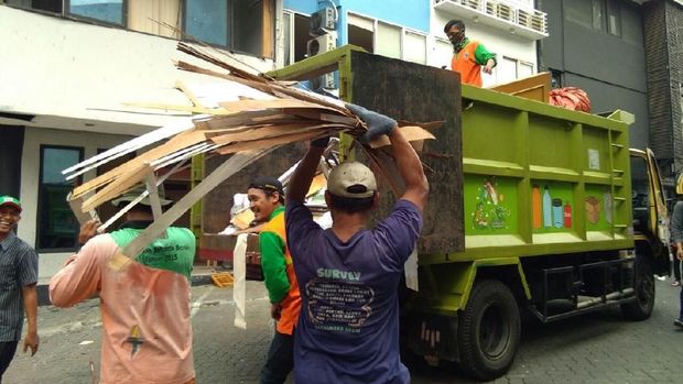 Pasukan oranye membersihkan sisa ledakan