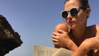 Sara hobi membaca. Ia kerap kali membawa buku saat berjemur di pantai. Ini gaya liburan Sara di Djibouti, Afrika Timur (johsara/Instagram)