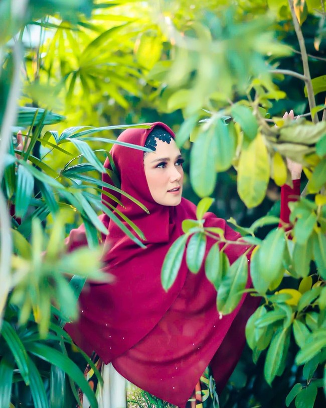 Ciput berwarna hitam itu Mulan padukan dengan hijab segi empat yang dipakai menjuntai menutup dada. Hijab warna merah itu dipadukan dengan dress motif bernuansa hijau.  Foto: Agung Wibowo