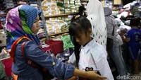 Warga berbelanja seragam sekolah di salah satu kios di Pasar Mayestik, Jakarta Selatan.