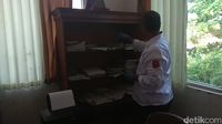 Polisi geledah salah satu ruang di kantor Desa Sekarwangi Karawang.