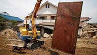 Alat berat juga membantu membersihkan rumah warga. REUTERS/Issei Kato.