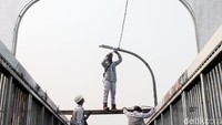 Sejumlah petugas Suku Dinas Perindustrian dan Energi Kota Administrasi Jakarta Timur terlihat sedang memperbaharui lampu di Jembatan Penyeberangan Orang (JPO) di Jalan Gatot Subroto, Jakarta Timur, Jumat (13/7/2018).