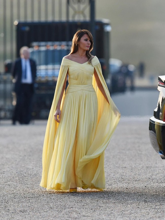 Saat menghadiri jamuan malam yang digelar oleh Perdena Menteri Inggris Theresa May, Melania Trump menebar pesonanya dalam balutan gaun kuning yang berhiaskan cape nan elegan. Gaun rancangan J.Mendel itu bernilai 5.300 poundsterling atau sekitar Rp 100 juta! (Foto: Dok. Getty Images)