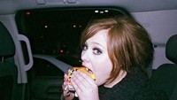 Pelantun lagu Someone Like You ini juga menyukai junk food. Lihat betapa lahapnya ia memakan burger In N Out di dalam mobil itu. Foto: Istimewa