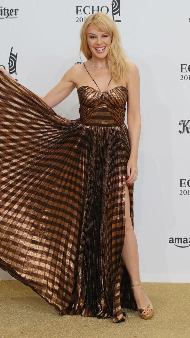 Penyanyi Kylie Minogue menginjak usia 50 pada 28 Mei lalu. Banyak yang memuji penampilan Kylie yang tak berubah sejak 25 tahun lalu. Penampilannya yang dulu justru terlihat lebih tua, tapi karena tidak memiliki perubahan sehingga kini ia tampak awet muda.  Foto: Getty Images