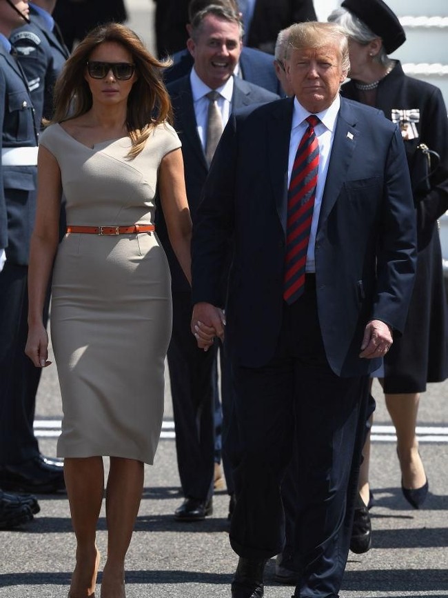 Tiba di Stansted Airport, Essex, Inggris, Kamis (12/7/2018), Melania muncul dalam balutan gaun cocktail berpotongan minimalis rancangan Rouland Mouret. Harganya US$ 1365 atau sekitar Rp 20 juta. Turut menyempurnakan gayanya, slim belt oranye yang mempertegas pinggul ramping ibu satu anak itu. (Foto: Getty Images)