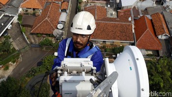 Petugas perawatan bekerja di atas ketinggian langit Jakarta.
