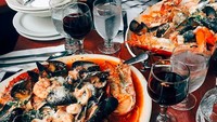 “Italy does it better!,” kata Amal. Wih, ada olahan seafood segar dengan pengiring red wine yang disantap Amal. Foto: amalclooneyofficial