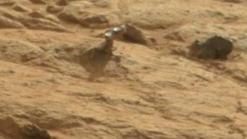 Gagang pintu. Obyek misterius yang terlihat metalik dan menyerupai gagang pintu ini ditemukan di foto yang diambil Curiosity pada tahun 2013. Tetapi, menurut NASA, obyek ini merupakan sebuah batu keras yang dipoles oleh angin. (Foto: NASA/JPL-Caltech)
