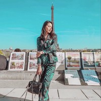 Setelan bermotif dalam nuansa hijau menjadi andalan Alyssa saat berpose di depan Menara Eiffel. Gayanya kian sempurna dengan sendal bergaya etnik serta tas hitam Balenciaga. (Foto: Instagram/alyssadaguise)