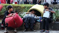 Beberapa anak beristirahat usai berjoget dengan mengenakan kostum badut.