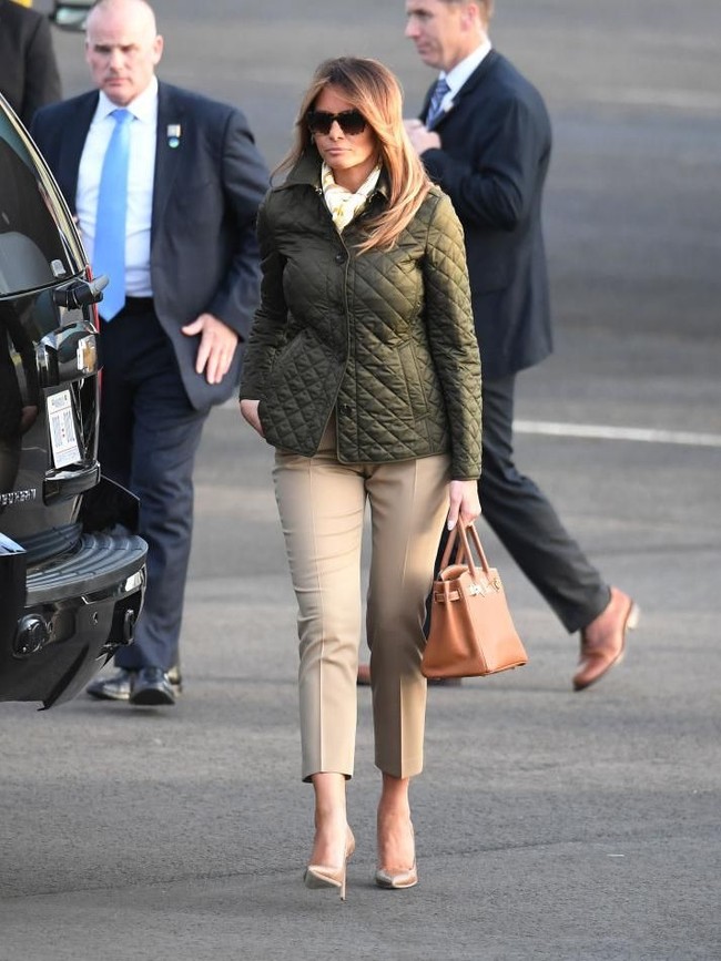 Bertolak ke Glasgow, Skotlandia, Melania mengandalkan jaket Burberry seharga Rp 8 juta yang dipadu dengan celana Michael Kors. Tampak sang Ibu Negara menenteng tas Birkin Hermes yang harganya bisa mencapai 10 ribu poundsterling lebih atau sekitar Rp 190 juta. (Foto: Getty Images)