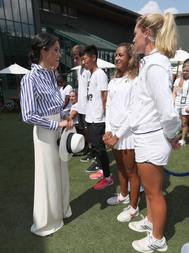 Meghan Markle untuk pertama kalinya muncul di Wimbledon sebagai Duchess of Sussex. Untuk momen istimewa tersebut, istri Pangeran Harry ini memilih gaya preppy chic nan modern dengan kemeja garis oversized dan wide legged pants krem. (Foto: Getty Images)