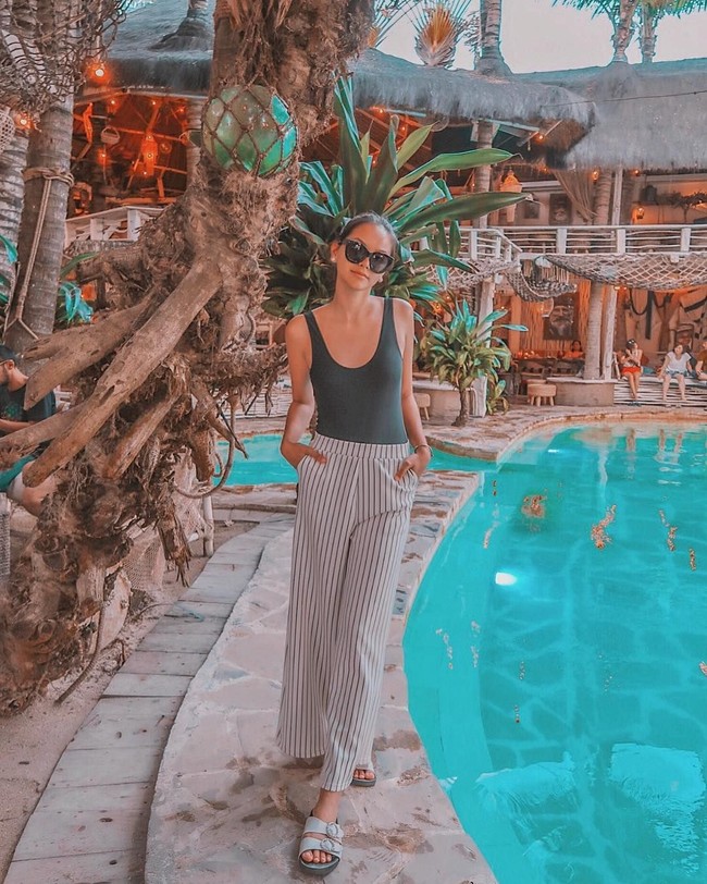 Alyssa meresapi gayanya yang holiday vibe di Bali dengan tank top hijau ketat dan celana lebar yang rileks. (Foto: Instagram/alyssadaguise)