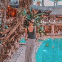 Alyssa meresapi gayanya yang holiday vibe di Bali dengan tank top hijau ketat dan celana lebar yang rileks. (Foto: Instagram/alyssadaguise)
