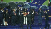Presiden Kroasia dan Presiden Prancis tidak keberatan hujan-hujanan. Ini momen saat mereka mencium trofi  Piala Dunia (Foto: Reuters)