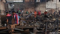 Petugas Damkar dan beberapa pekerja dari gudang tampak mengmpulkan puing-puing sisa kebakaran.