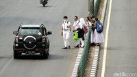 Beberapa orang pelajar terlihat sedang menyeberang di jalanan besar tanpa melalui jembatan penyeberangan orang ataupun garis penyeberangan.