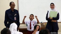 Para murid bersemangat menceritakan pengalaman liburan di depan kelas.