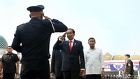 Jokowi memberikan hormat kepada pimpinan upacara di lapangan. Pimpinan upacara melaporkan mengenai acara bela negara.