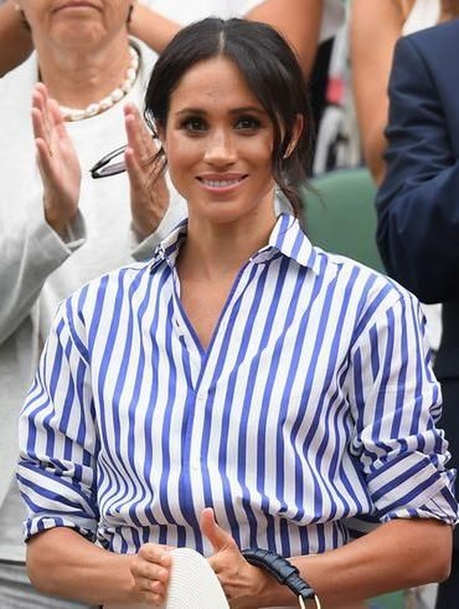Meghan Markle selalu menata rambutnya dengan elegan dan natural. Saat digerai maupun disanggul, ia membiarkan rambut bagian depannya jatuh membingkai wajah. Trik ini membuat wajah terlihat lebih cantik dan memiliki efek lebih tirus. Foto: Dok. Getty Images