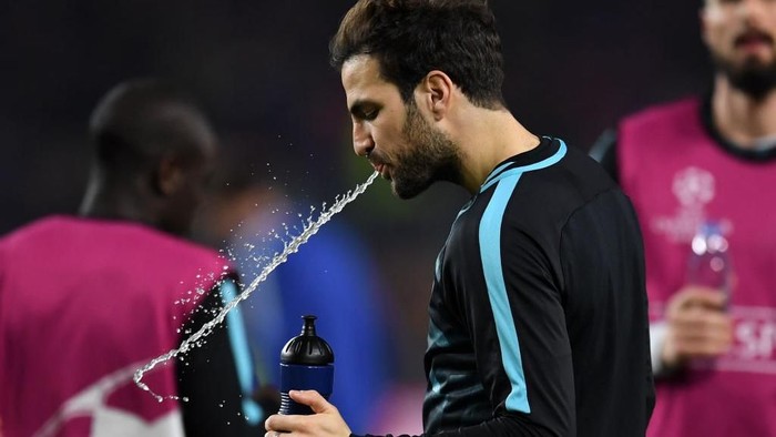 Seorang pemain sepakbola menyemburkan lagi air minum setelah berkumur (Foto: Getty Images) Seorang pemain sepakbola menyemburkan lagi air minum setelah berkumur (Foto: Getty Images)