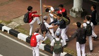 Meski sudah dilerai, perkelahian berlanjut di trotoar jalan.