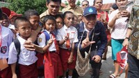 Di sela-sela kunjungan, para siswa SD berebut foto dengan membuat simbol tangan Salam Literasi.