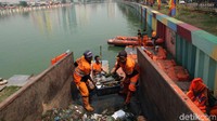 Para petugas sedang memindahkan sampah yang telah dikumpulkan dari sekitaran Danau Sunter ke mobil sampah PPSU.