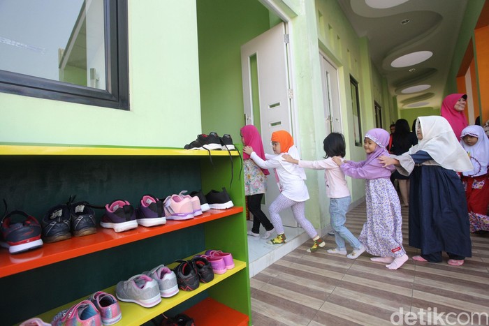 Sejumlah orang tua mengantarkan anaknya dihari pertama masuk sekolah di Taman Kanak-kanak. Disana anak-anak ini terlihat sangat menggemaskan.