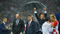 Meski hujan-hujanan, Macron dan Grabar-Kitarović tak berhenti mengucapkan selamat kepada 2 tim yang bertanding di final (Foto: Reuters)