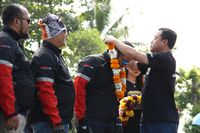 Direktur Sales PT Yamaha Indonesia Motor Manufacturing (YIMM) Sutarya mengalungkan bunga kepada rider MAXI Tour de Indonesia (Foto: dok. Yamaha)