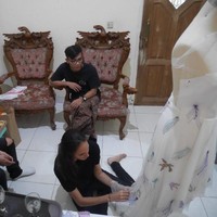Foto ini diambil saat Nadine dan Dimas berkunjung ke workshop Abduh yang berlokasi di kawasan Pondok Gede, Jakarta Timur, sekitar 1,5 bulan sebelum acara resepsi. Berbusana serba hitam, Nadine terlihat duduk di lantai dan menjahit detail ubur-ubur pada gaunnya. (Foto: Dok. Surya Abduh)