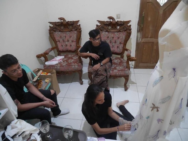 Foto ini diambil saat Nadine dan Dimas berkunjung ke workshop Abduh yang berlokasi di kawasan Pondok Gede, Jakarta Timur, sekitar 1,5 bulan sebelum acara resepsi. Berbusana serba hitam, Nadine terlihat duduk di lantai dan menjahit detail ubur-ubur pada gaunnya. (Foto: Dok. Surya Abduh)