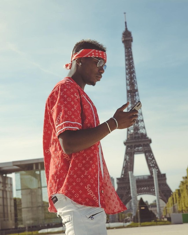 Berpose di depan Menara Eiffel, Paul Pogba tampil kekinian dengan baseball t-shirt Supreme x Louis Vuitton seharga 650 poundsterling atau sekitar Rp 12 juta. Bandana di kepalanya juga bermerek sama, harganya Rp 5,3 juta. (Foto: Instagram/@paulpogba)
