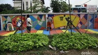 Sejumlah warga membuat mural Asian Games di depan Wisma Atlet Kemayoran, Kelurahan Kebon Kosong, Jakarta Pusat, Senin (16/7).