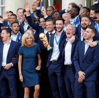 Setelah memenangkan Piala Dunia, tim Prancis kembali ke negaranya. Disambut dengan pesawat jet yang menebarkan asap warna merah, putih dan biru. Para tim berparade sebelum akhirnya sampai di Elysee Palace, Paris, tempat Presiden dan Ibu Negara menunggu. Foto: Philippe Wojazer/Reuters
