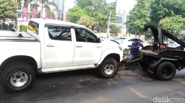 Mobil dievakuasi dengan cara ditarik mobil derek